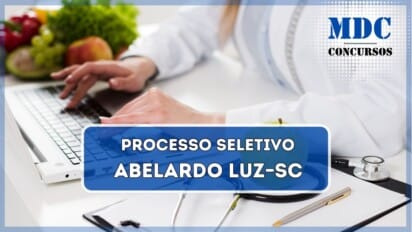 A imagem mostra uma profissional da área da saúde vestindo um jaleco branco enquanto digita em um laptop. Sobre a mesa branca, há um estetoscópio, uma prancheta com folhas de papel, uma caneta dourada e uma maçã verde. Ao fundo, é possível ver uma variedade de frutas e vegetais frescos, incluindo uvas, maçãs e alface, sugerindo uma ênfase em saúde e nutrição / Prefeitura de Abelardo Luz anuncia processo seletivo para cadastro reserva