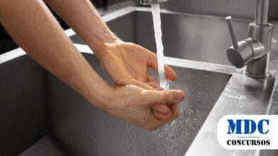 Processos Seletivos 5 Pessoa lavando as mãos em uma pia de inox, com água corrente saindo de uma torneira prateada / SAMAE de Jardim Olinda PR lança Processo Seletivo - PSS