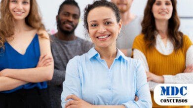 Grupo de cinco pessoas com expressões confiantes e braços cruzados, destacando uma mulher de camisa azul sorridente no centro. Eles estão em um ambiente profissional ou colaborativo, com roupas casuais e formais. A imagem transmite liderança, diversidade e trabalho em equipe - Açailândia (MA) Oferece Salários de até R$ 4,4 mil em Processo Seletivo