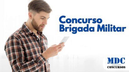 Homem jovem com barba e cabelo castanho curto, vestindo camisa xadrez, olhando para seu smartphone com expressão concentrada. O fundo é branco e iluminado, criando um contraste com sua roupa escura - Brigada Militar Abre Concurso com 1.200 Vagas e Salário de R$ 5.944,85