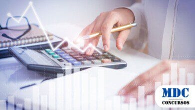 Mãos de uma pessoa digitando em uma calculadora com uma caneta dourada na mão, ao lado de um caderno e óculos sobre a mesa. Sobreposição de gráficos digitais com barras e linhas ascendentes, representando análise financeira, contabilidade ou planejamento econômico - Concurso SEFAZ PI 80 Vagas e Remuneração de até R$ 27,6 Mil