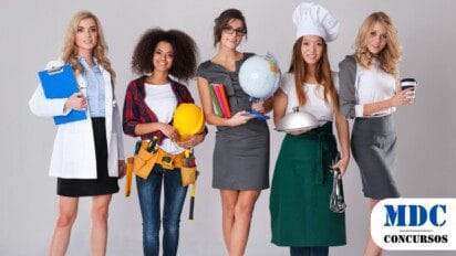 Cinco mulheres em diferentes trajes profissionais representam várias carreiras: médica com jaleco e prancheta, operária com capacete e ferramentas, professora segurando um globo, chef de cozinha com avental e bandeja, e executiva com roupa formal e café. Elas posam juntas contra um fundo neutro, simbolizando diversidade profissional no mercado de trabalho - Concurso em Águas de São Pedro (SP) abre 34 vagas com salários de até R$ 3,6 mil