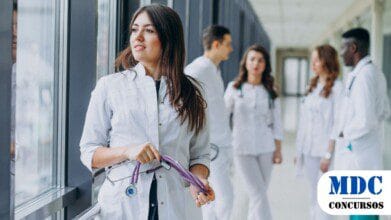 Processos Seletivos 3 Jovem médica olhando a janela do corredor do hospital / Prefeitura de Anori – AM lança Processo Seletivo com 230 Vagas e Salários de até R$ 9 mil