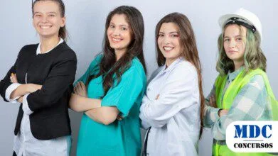Quatro mulheres posam sorridentes de braços cruzados, representando diferentes profissões. Da esquerda para a direita: uma executiva de terno preto, uma profissional de saúde de jaleco verde, uma médica de jaleco branco e uma engenheira com capacete branco e colete refletivo amarelo. Todas estão alinhadas contra um fundo branco, simbolizando diversidade profissional / Processo Seletivo em Alto Piquiri – PR Oferece 23 Vagas + CR com Salários de Até R$ 17,1 mil