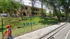 Fachada da sede da ADAB com prédio amarelo ao fundo, área arborizada, grade com logotipo ADAB e calçada com pedestre passando em frente ao local. Foto: Divulgação/Google Maps
