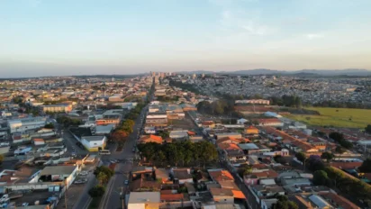 Vista aérea de Alfenas com áreas urbanas, ruas alinhadas, casas e prédios ao fundo, além de campos abertos e montanhas no horizonte ao entardecer. Foto: Divulgação/Prefeitura de Alfenas-MG
