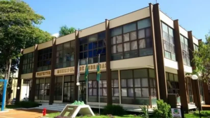 Fachada da Prefeitura Municipal de Andradas com prédio de dois andares, janelas amplas, bandeiras em frente e área arborizada ao redor. Foto: Divulgação/Prefeitura de Andradas-MG