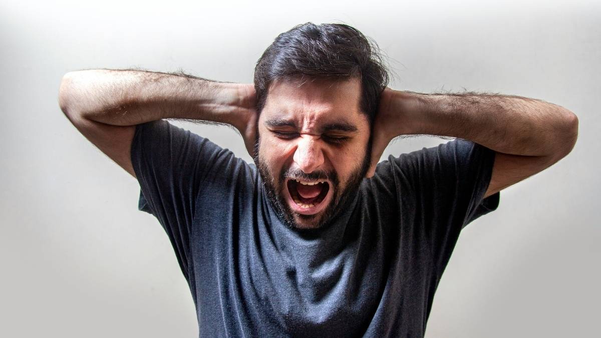 Ansiedade: como lidar com ela antes da prova em concursos 1 Ansiedade: Homem com expressão de estresse, olhos fechados, boca aberta e mãos na cabeça. Foto: Usman Yousaf/Unsplash