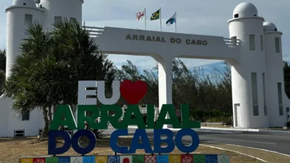 Portal de entrada de Arraial do Cabo com letreiro “Eu amo Arraial do Cabo”, bandeiras hasteadas e torres brancas ao fundo. Foto: Divulgação/Prefeitura de Arraial do Cabo-RJ