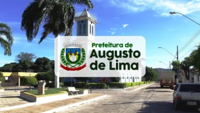Vista da praça central de Augusto de Lima, Minas Gerais, com destaque para a torre da igreja ao fundo e o brasão da prefeitura sobreposto no centro da imagem.