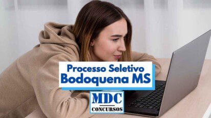 Mulher jovem com expressão concentrada está sentada à frente de um notebook, vestindo moletom bege, em ambiente interno com cortinas brancas ao fundo. Sobre a imagem, há uma arte gráfica com os dizeres “Processo Seletivo Bodoquena MS” em destaque, seguida pelo logotipo “MDC Concursos”. A imagem remete ao anúncio de vagas temporárias na Prefeitura de Bodoquena, Mato Grosso do Sul.