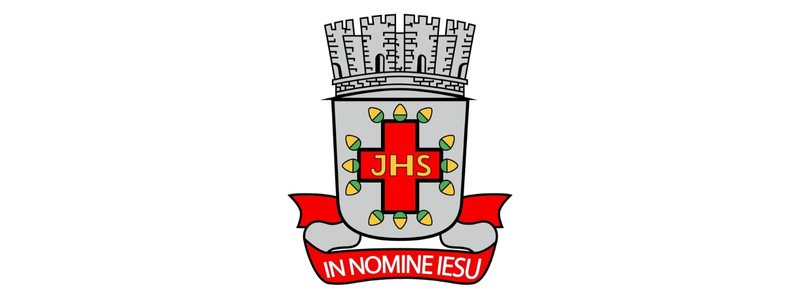 Brasão de Santo Antônio de Jesus-BA com coroa mural, cruz vermelha central com as letras JHS e faixa vermelha com a inscrição “In Nomine Iesu”
