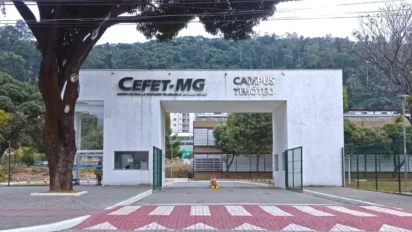Fachada branca da entrada do Campus Timóteo do CEFET-MG, com o nome da instituição em destaque e uma grande abertura central para circulação. Foto: HVL/Wikimedia