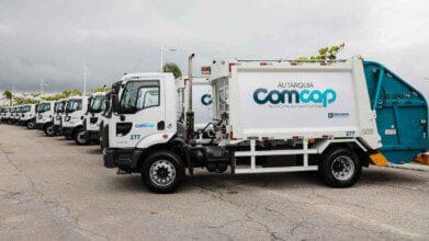 Processos Seletivos 5 Caminhões de coleta de lixo da COMCAP enfileirados, com destaque para veículo identificado com logotipo da autarquia e slogan "Nova Comcap, nossa Comcap". Foto: Divulgação/Prefeitura de Florianópolis