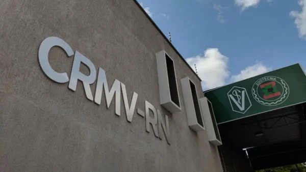 CRMV-RN abre concurso público com 80 vagas para Nível Médio 3 Fachada do prédio do CRMV-RN com a sigla em destaque na parede e placa institucional verde ao fundo sob céu parcialmente nublado. Foto: Divulgação/CRMV-RN