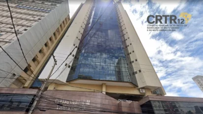 Fachada de prédio comercial alto com fachada de vidro, vista em perspectiva de baixo para cima, com logotipo do CRTR-12 no canto superior direito da imagem. Foto: Divulgação/Google Maps