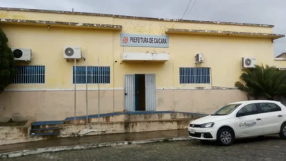 Fachada da Prefeitura de Caiçara, na Paraíba, com prédio amarelo, janelas com grades azuis e carro oficial da Saúde estacionado em frente. Foto: Divulgação/Prefeitura de Caiçara-PB