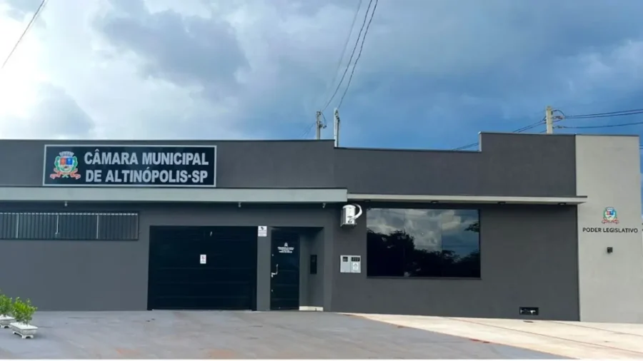 Fachada moderna e cinza da Câmara Municipal de Altinópolis, em São Paulo, sob céu nublado.