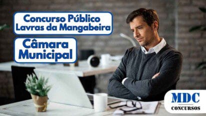 Homem de aparência séria, vestindo suéter cinza sobre camisa branca, está sentado em um escritório moderno com fundo de tijolos aparentes, braços cruzados, olhando para um laptop aberto sobre a mesa. Ao lado, há uma xícara branca, óculos e documentos. O ambiente tem iluminação suave e decoração minimalista com plantas e objetos organizados - Câmara de Lavras da Mangabeira (CE) lança Concurso Público