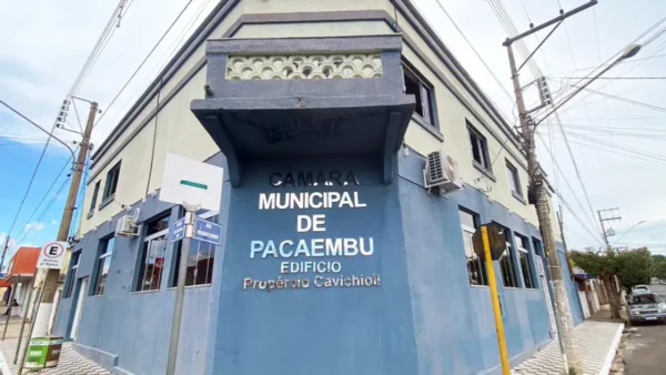 Fachada de esquina do edifício da Câmara Municipal de Pacaembu, em São Paulo, com paredes em tons de azul e bege, destacando o letreiro metálico com o nome da instituição e do Edifício Propércio Cavichioli. Foto: Divulgação/Câmara de Pacaembu-SP