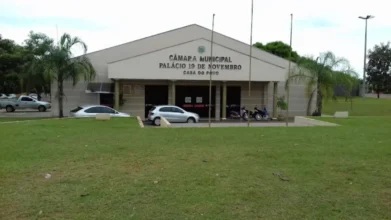 Fachada da Câmara Municipal de Teodoro Sampaio, o Palácio 19 de Novembro, com gramado frontal e carros estacionados.