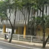 Fachada da Câmara Municipal de Volta Redonda/RJ com estrutura moderna, colunas verticais, árvores na calçada e pessoas caminhando pela rua. Foto: Divulgação/Câmara Municipal de Volta Redonda-RJ