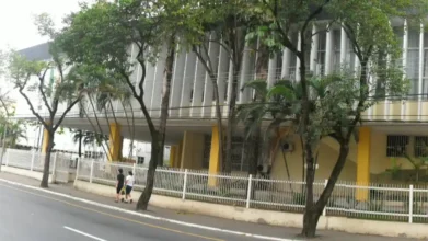 Concursos 6 Fachada da Câmara Municipal de Volta Redonda/RJ com estrutura moderna, colunas verticais, árvores na calçada e pessoas caminhando pela rua. Foto: Divulgação/Câmara Municipal de Volta Redonda-RJ