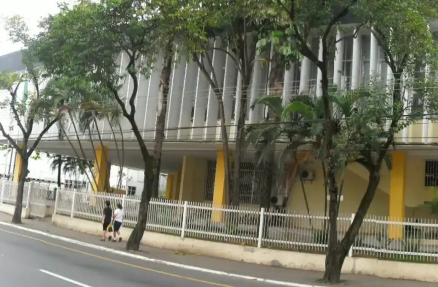 Fachada da Câmara Municipal de Volta Redonda/RJ com estrutura moderna, colunas verticais, árvores na calçada e pessoas caminhando pela rua. Foto: Divulgação/Câmara Municipal de Volta Redonda-RJ