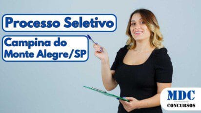 Mulher sorridente com cabelo loiro ondulado, vestindo blusa preta e jeans, segura uma prancheta verde e uma caneta azul em fundo cinza claro - Campina do Monte Alegre – SP abre 28 vagas com salários de até R$ 2,7 mil