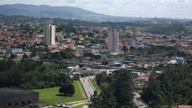 Processos Seletivos 6 Vista aérea de Campo Limpo Paulista com prédios residenciais, casas, áreas verdes e montanhas ao fundo. Foto: João Batista Shimoto/Wikipédia
