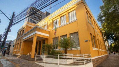 Sede da Prefeitura de Canoas em prédio amarelo com bandeira hasteada na entrada. Foto: Divulgação/Prefeitura de Canoas-RS