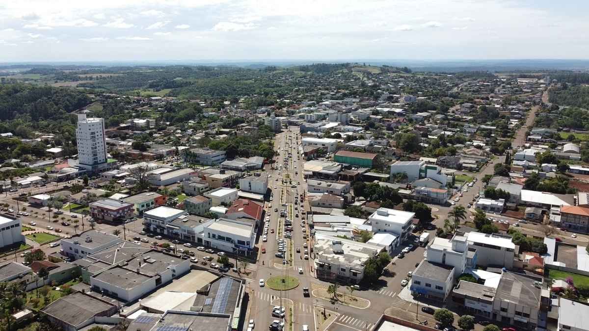 Vista aérea da cidade de Capanema-PR com avenida central, prédios comerciais, residenciais e área verde ao fundo. Foto: Divulgação/Prefeitura de Capanema-PR