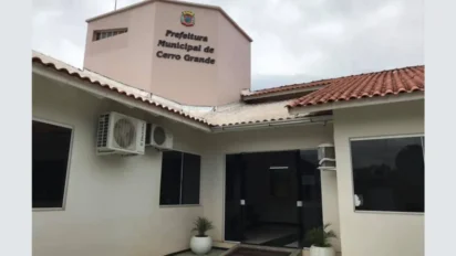 Fachada da Prefeitura Municipal de Cerro Grande, no Rio Grande do Sul, apresentando prédio de cor clara, telhado de barro e letreiro com o brasão da cidade.
