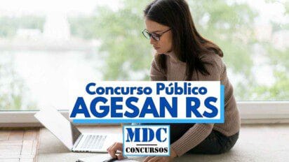 Mulher sentada no chão em frente a uma grande janela, utilizando um notebook e fazendo anotações em um caderno, sugerindo que estuda para concurso. Ela usa óculos e está concentrada. Em destaque, há uma faixa com os dizeres "Concurso Público AGESAN RS" e o logotipo "MDC Concursos", indicando que a imagem se refere a um processo seletivo no Rio Grande do Sul.