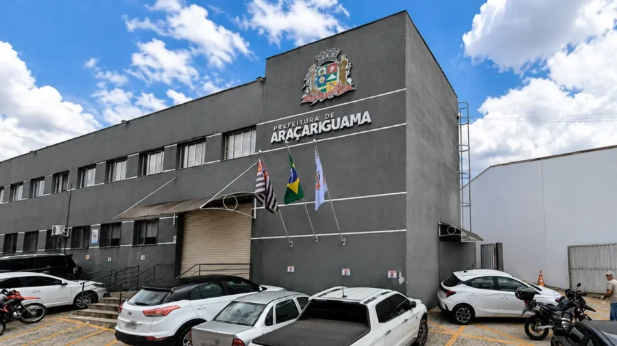 Fachada da Prefeitura de Araçariguama com brasão municipal e bandeiras, concurso Araçariguama SP