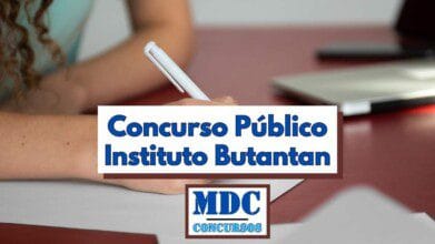 Imagem com foco em uma pessoa escrevendo com uma caneta branca sobre uma folha de papel, em uma mesa vermelha. Ao fundo, há um notebook desfocado. No centro da imagem, há uma tarja com os dizeres "Concurso Público Instituto Butantan" em letras azuis. Abaixo, o logotipo da MDC Concursos com texto em azul sobre fundo branco e bordas marrons