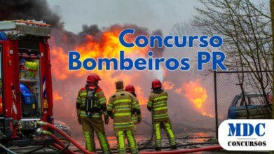 Bombeiros combatendo um grande incêndio com chamas intensas e fumaça preta densa, utilizando mangueiras de alta pressão. Eles vestem trajes de proteção com faixas refletivas e capacetes vermelhos. Um caminhão de bombeiros com equipamentos está ao lado, e mangueiras estão espalhadas no chão. Um carro queimado e uma cerca aparecem à esquerda - Concurso CBMPR abre 600 vagas com até R$ 6.101 de remuneração