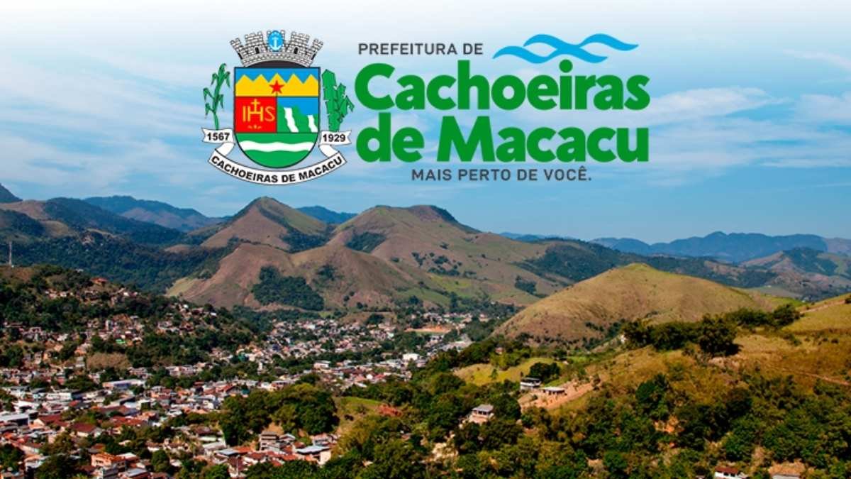 Vista panorâmica de Cachoeiras de Macacu com morros ao fundo, brasão do município e texto da prefeitura em destaque. Foto: Divulgação/Prefeitura de Cachoeiras de Macacu-RJ
