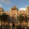 Prédio histórico rosa com palmeiras, sede do concurso Companhia Docas do Pará
