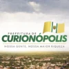 Logomarca da Prefeitura de Curionópolis com vista aérea da cidade, referente ao concurso Curionópolis PA
