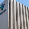 Fachada do prédio da Dataprev com logotipo colorido e céu azul no concurso Dataprev