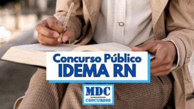 Pessoa segurando um caderno e escrevendo com um lápis, usando roupas sociais em tons claros, com a imagem focada nas mãos e no material de estudo; sobre a imagem há uma faixa branca e azul com o texto Concurso Público IDEMA RN em letras grandes e o logotipo da MDC Concursos logo abaixo