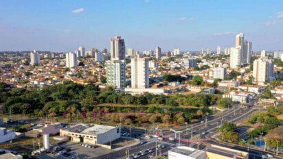 Vista aérea da cidade de Indaiatuba, com destaque para prédios residenciais, áreas arborizadas e vias urbanas movimentadas.