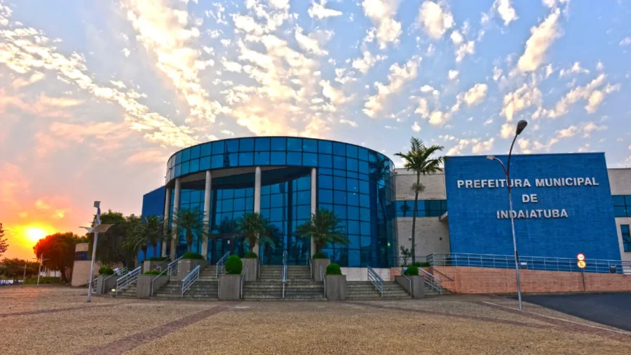 Fachada azul e envidraçada da Prefeitura de Indaiatuba, sede do concurso Indaiatuba SP, ao pôr do sol