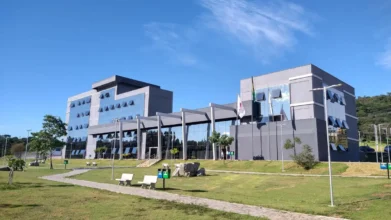 Sede da prefeitura - prédio público moderno com bandeiras do Brasil e de Minas, alusivo ao concurso Itaúna MG