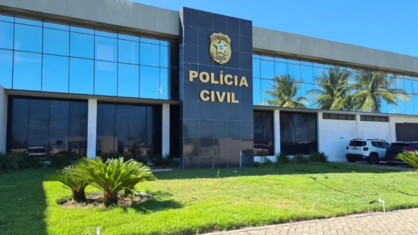 Concurso PCAL 2026 abre 300 vagas com salário inicial de R$ 5.318,63 3 Fachada de vidro da sede da Polícia Civil de Alagoas com letreiro e palmeiras, concurso PCAL