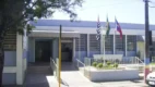 Fachada azul de prédio público com três bandeiras hasteadas, cenário do concurso Piraju SP