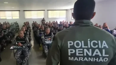 Policial de costas com farda da Polícia Penal do Maranhão diante de turma no concurso Polícia Penal MA