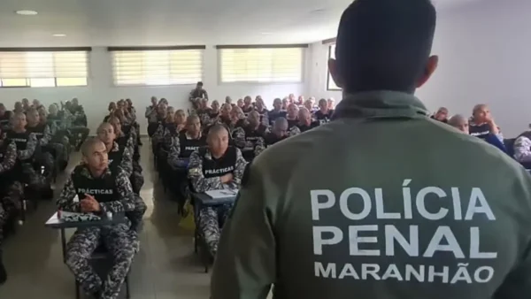 Policial de costas com farda da Polícia Penal do Maranhão diante de turma no concurso Polícia Penal MA