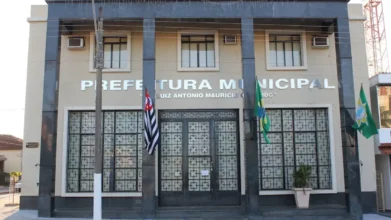 Fachada da Prefeitura Municipal de Potirendaba com bandeiras do estado de São Paulo e do Brasil, sede do concurso Potirendaba SP
